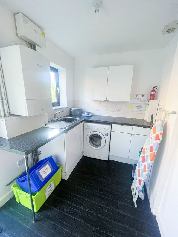 Betula House Image of the Utility Room showing washing machine, sink and ironing table