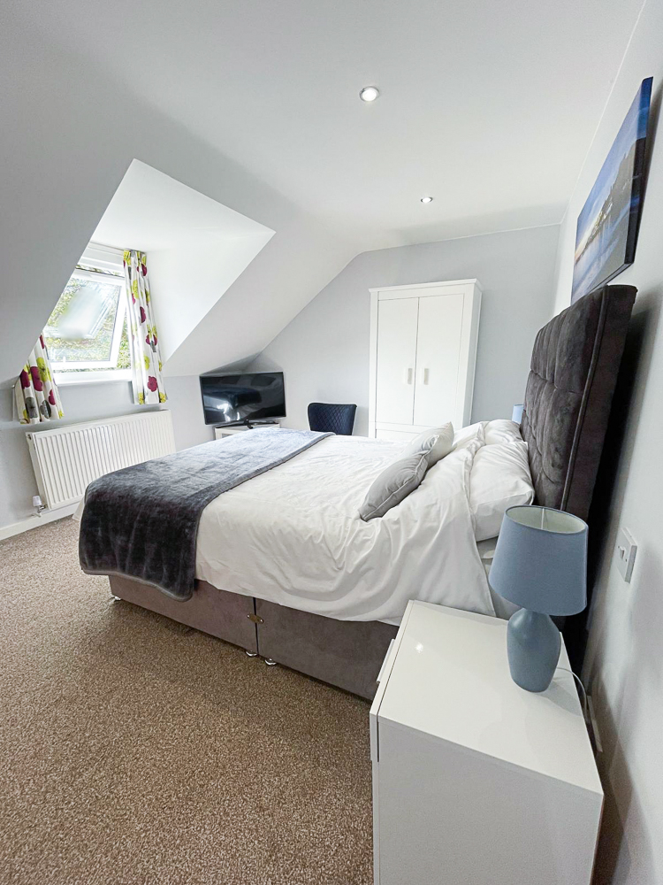 Betula House, master bedroom. Showing bed, cupboards and doorways to hall and en-suite bathroom. 
